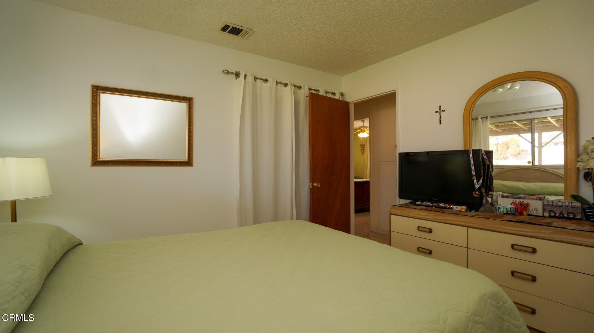 1121 Yale Street Oxnard, CA 93033 - Photo 14 of 22 a bedroom with a bed and a flat screen tv