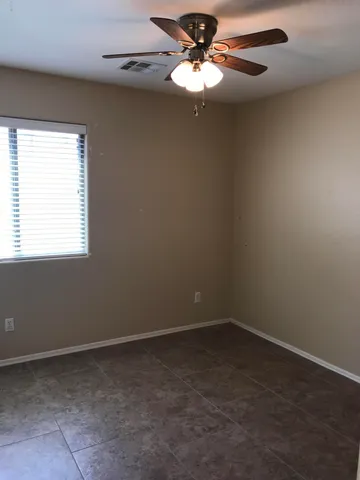 an empty room with a window and a fan