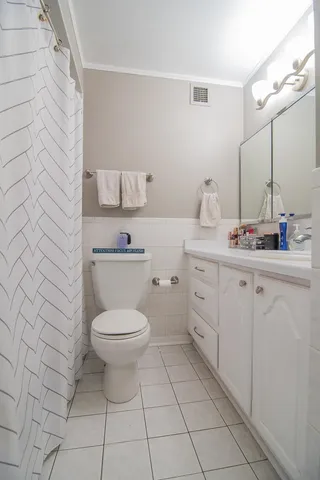 a bathroom with a toilet sink vanity and mirror
