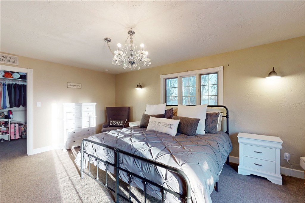 1473 Willow Road Nipomo, CA 93444 - Photo 24 of 52 a bedroom with a bed and a chandelier