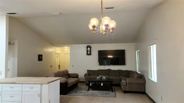 a living room with furniture chandelier and a flat screen tv