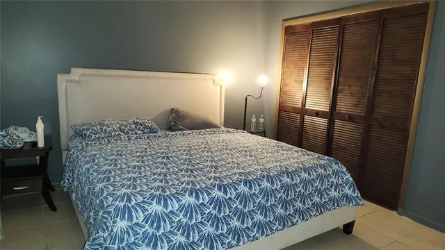 a bedroom with a large bed and a chandelier