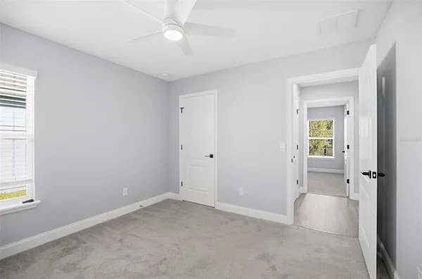 an empty room with a ceiling fan and a window