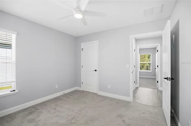 an empty room with a ceiling fan and a window