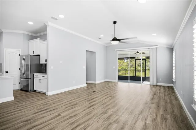 a view of an empty room with window and wooden floor
