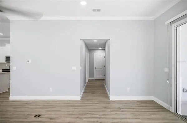a view of an empty room with wooden floor