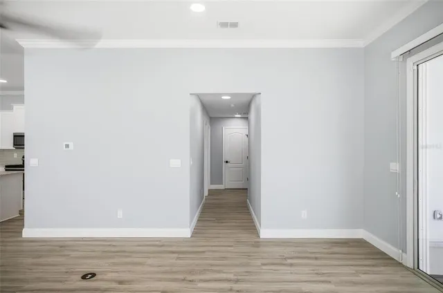 a view of an empty room with wooden floor
