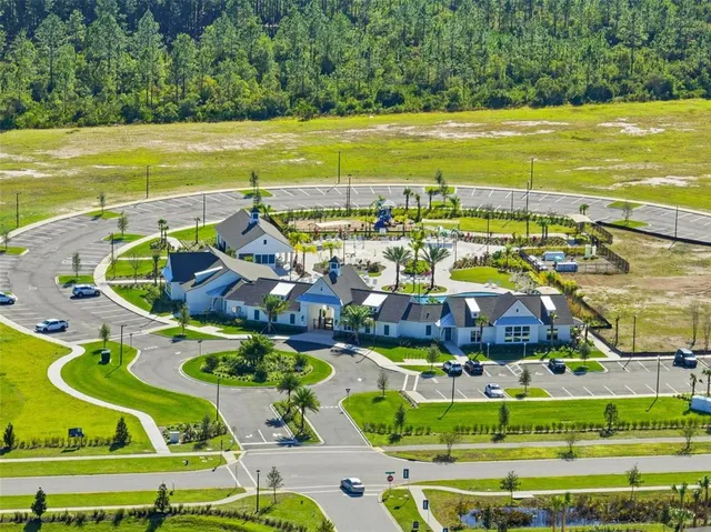 an aerial view of a house with outdoor space and trees all around