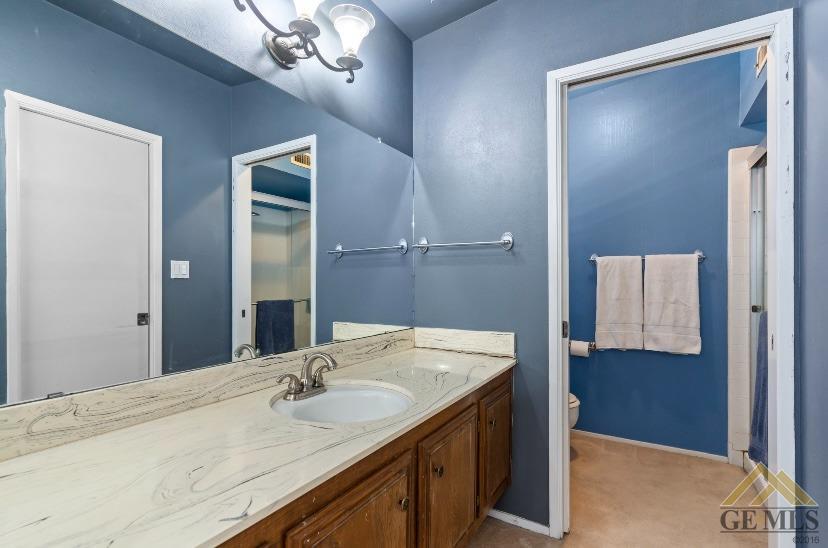 Undisclosed Address Bakersfield, CA 93309 - Photo 12 of 18 a bathroom with a granite countertop sink and a mirror