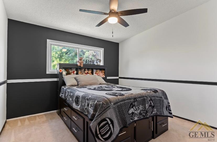 Undisclosed Address Bakersfield, CA 93309 - Photo 7 of 18 a bedroom with a bed a window and a chandelier