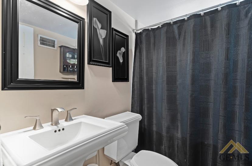 Undisclosed Address Bakersfield, CA 93309 - Photo 9 of 18 a bathroom with a sink mirror and toilet