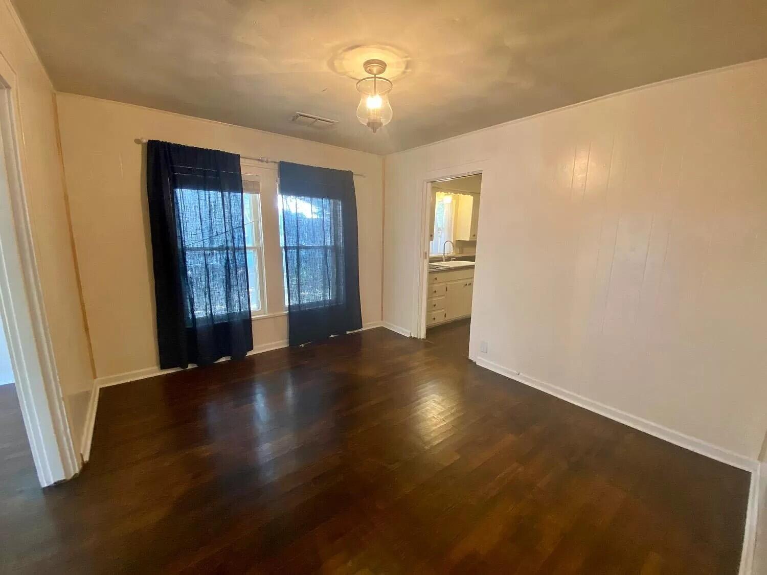 2109 22nd Street, Unit FRONT Lubbock, TX 79411 - Photo 10 of 16 a view of an empty room with wooden floor and a window