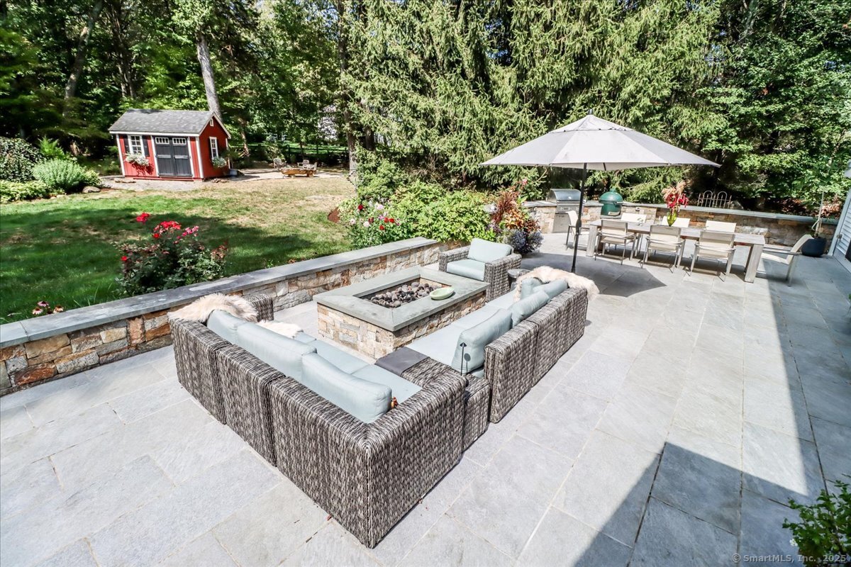 81 Graenest Ridge Road Wilton, CT 06897 - Photo 14 of 39 a view of a patio with couches and a table and chairs under an umbrella