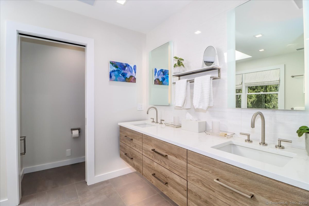 81 Graenest Ridge Road Wilton, CT 06897 - Photo 16 of 39 a spacious bathroom with a double vanity sink and a mirror