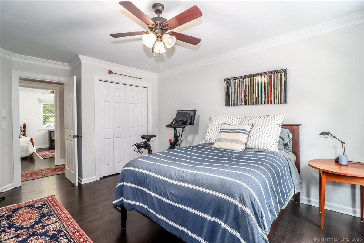 81 Graenest Ridge Road Wilton, CT 06897 - Photo 24 of 39 a bedroom with a bed and a chandelier