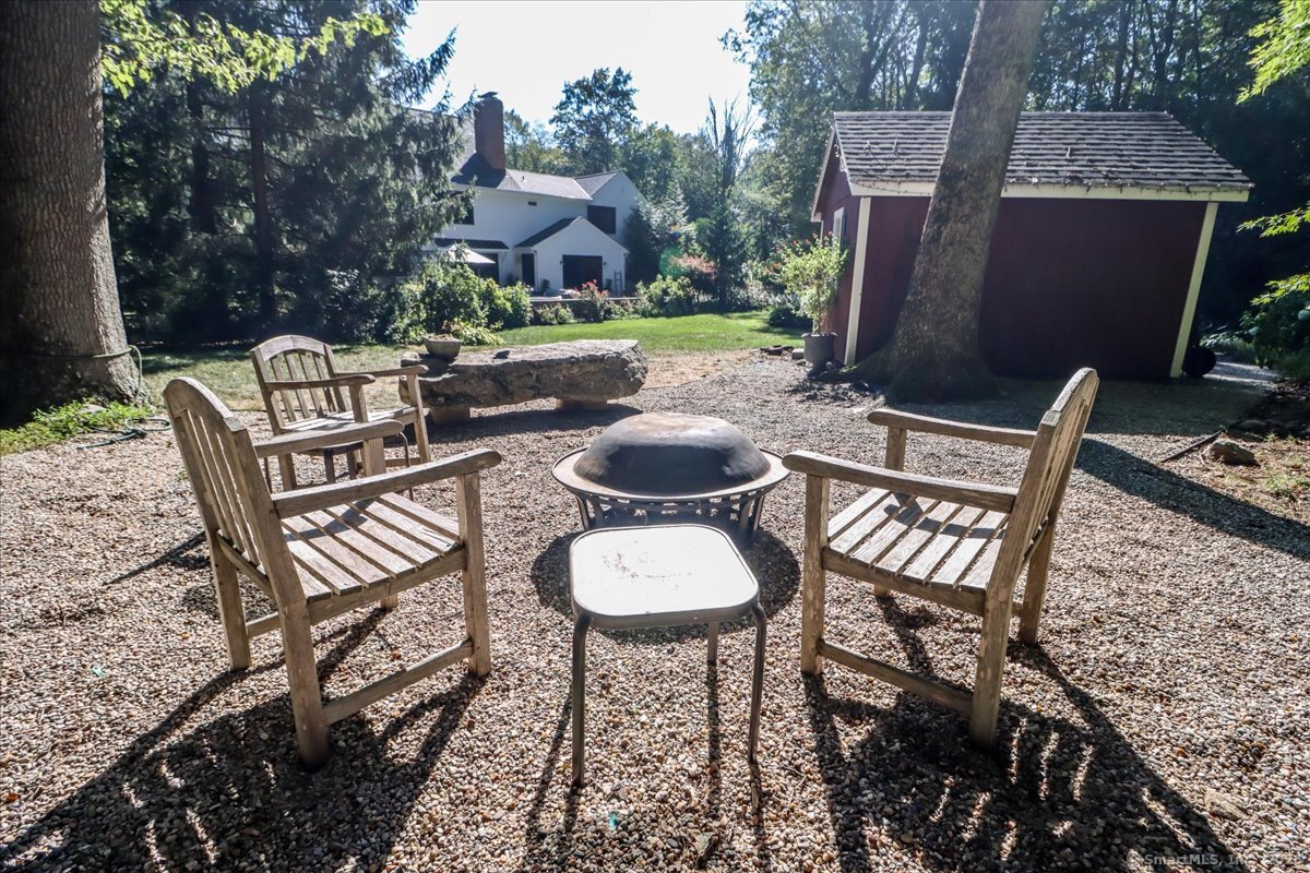 81 Graenest Ridge Road Wilton, CT 06897 - Photo 32 of 39 a view of a chairs and table in backyard