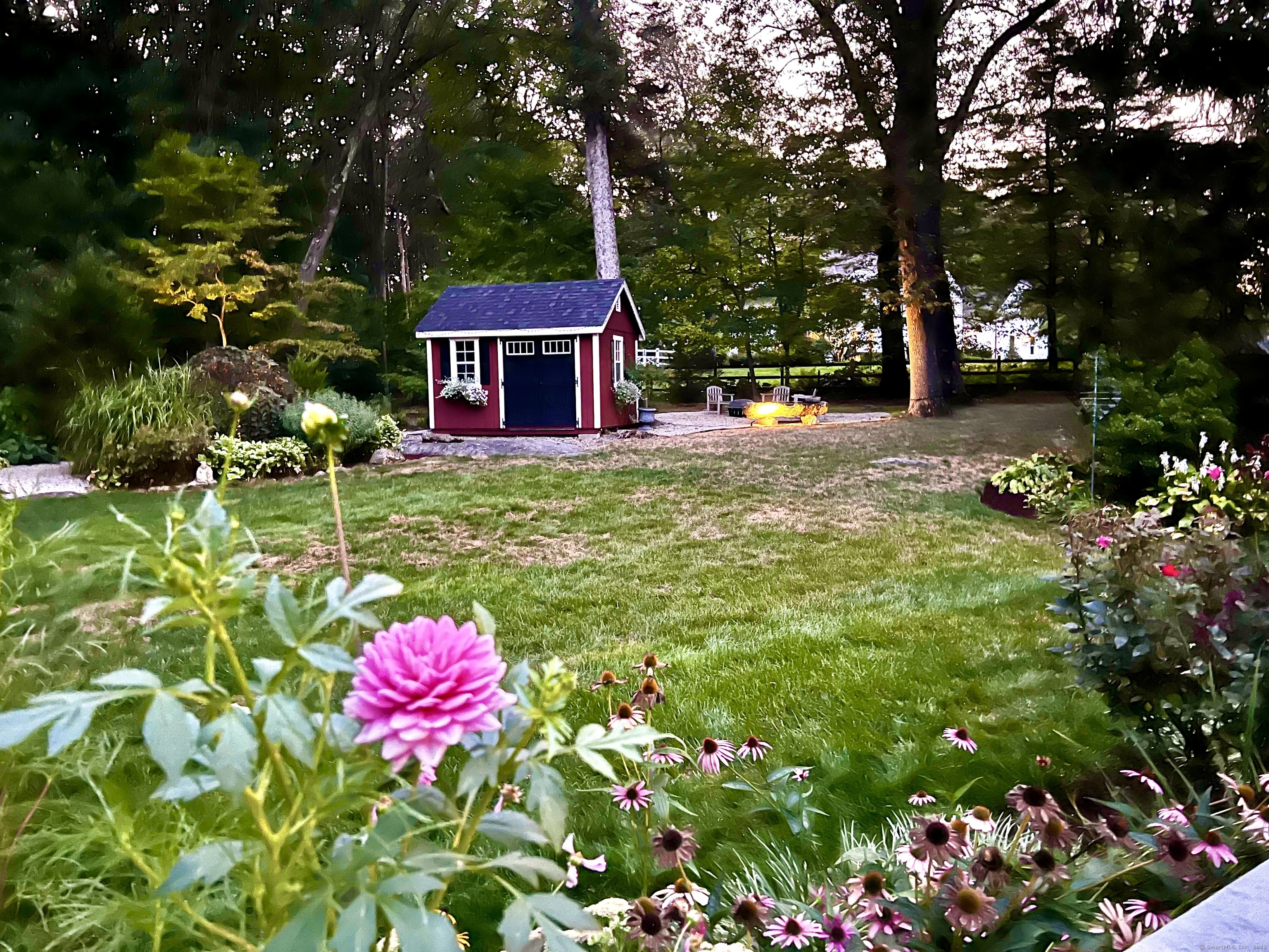 81 Graenest Ridge Road Wilton, CT 06897 - Photo 37 of 39 a backyard of a house with table and chairs and wooden fence