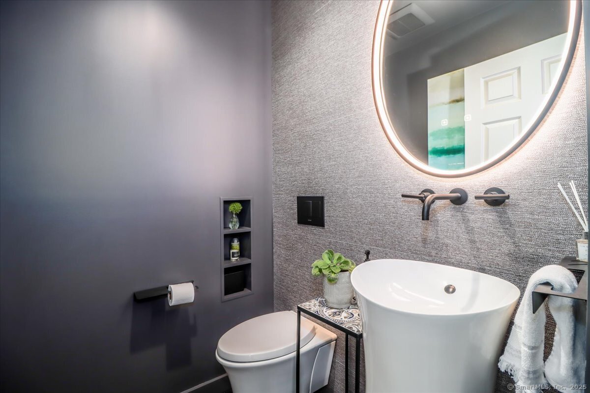 81 Graenest Ridge Road Wilton, CT 06897 - Photo 7 of 39 a white toilet sitting next to a bathroom sink