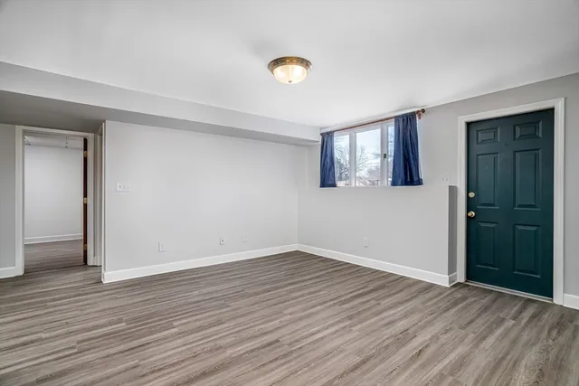 a view of an empty room with wooden floor and closet