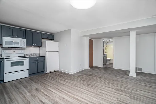 a view of a kitchen with wooden floor and electronic appliances