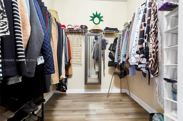a view of walk in closet with clothes and shoes