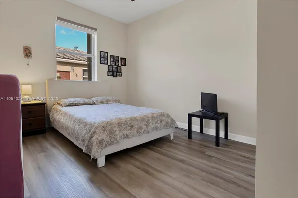 a bedroom with a bed table and a window