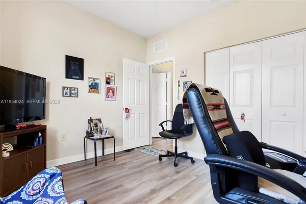 a view of a workspace with furniture and a window