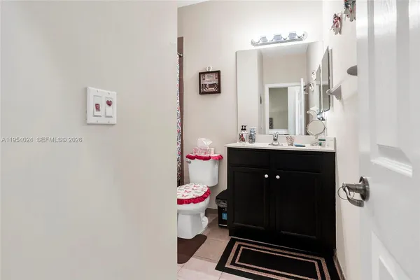 a bathroom with a sink vanity mirror and toilet