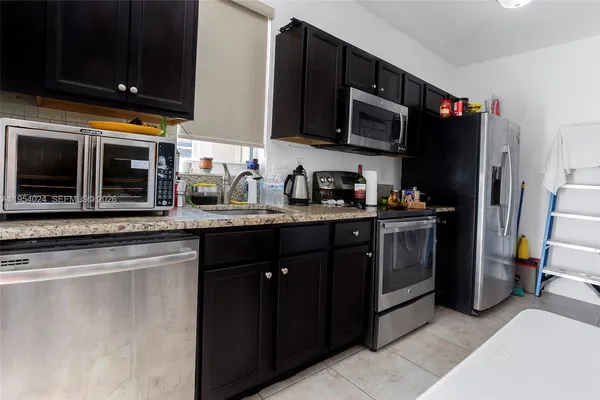 a kitchen with stainless steel appliances granite countertop a refrigerator stove and microwave