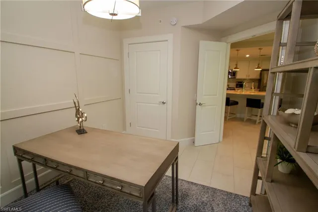 a room with a table chairs and refrigerator