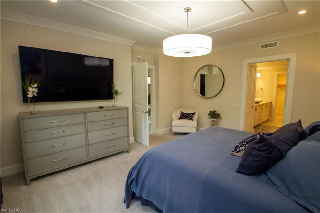 172 Indies Drive East, Unit 8102 Naples, FL 34114 - Photo 15 of 49 a bedroom with a bed and a flat screen tv