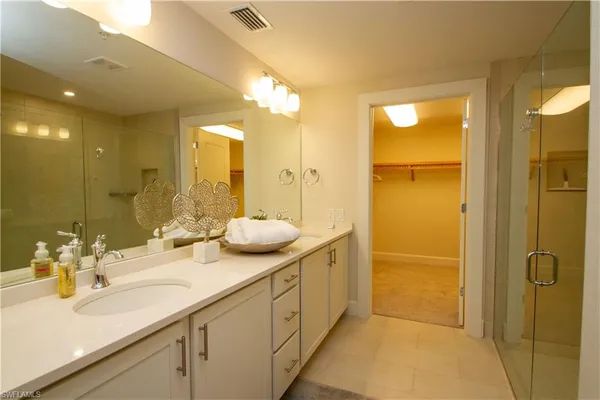 a bathroom with a double vanity sink mirror and shower