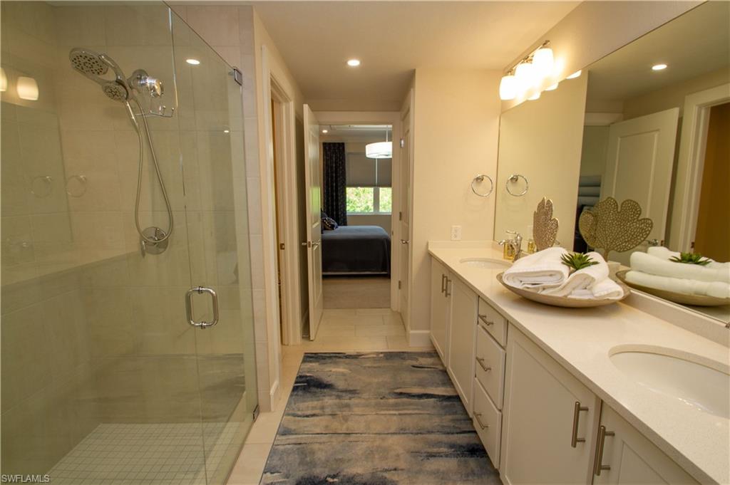 172 Indies Drive East, Unit 8102 Naples, FL 34114 - Photo 19 of 49 a bathroom with a granite countertop sink a toilet and shower