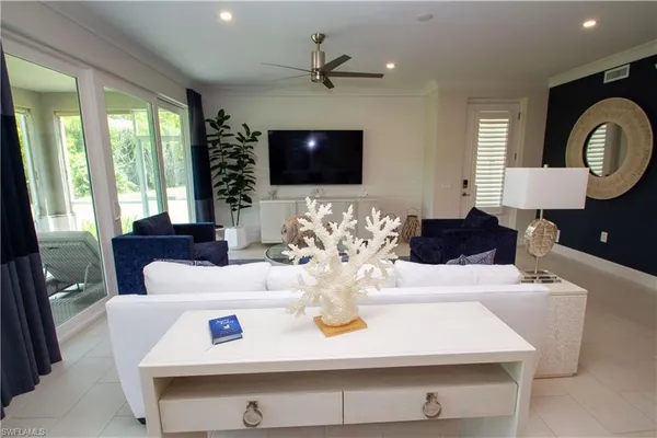 a living room with furniture chandelier and a flat screen tv