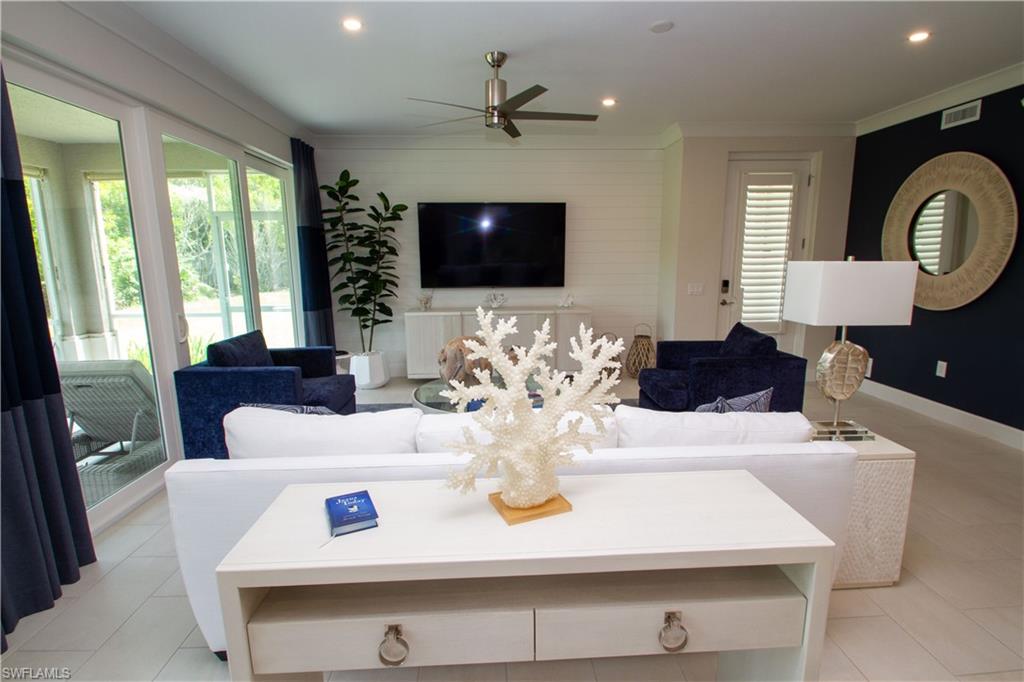 172 Indies Drive East, Unit 8102 Naples, FL 34114 - Photo 21 of 49 a living room with furniture chandelier and a flat screen tv