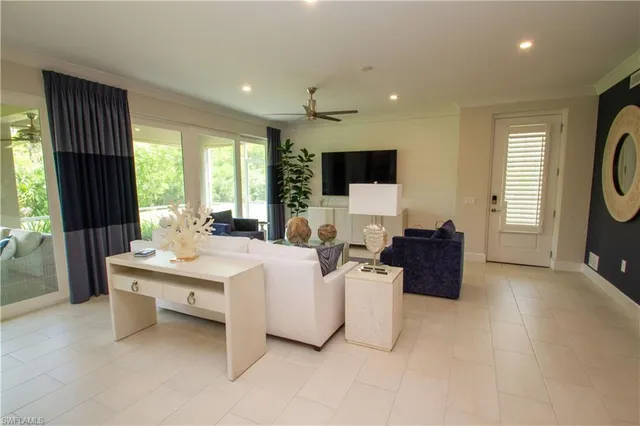 a living room with furniture a flat screen tv and a large window