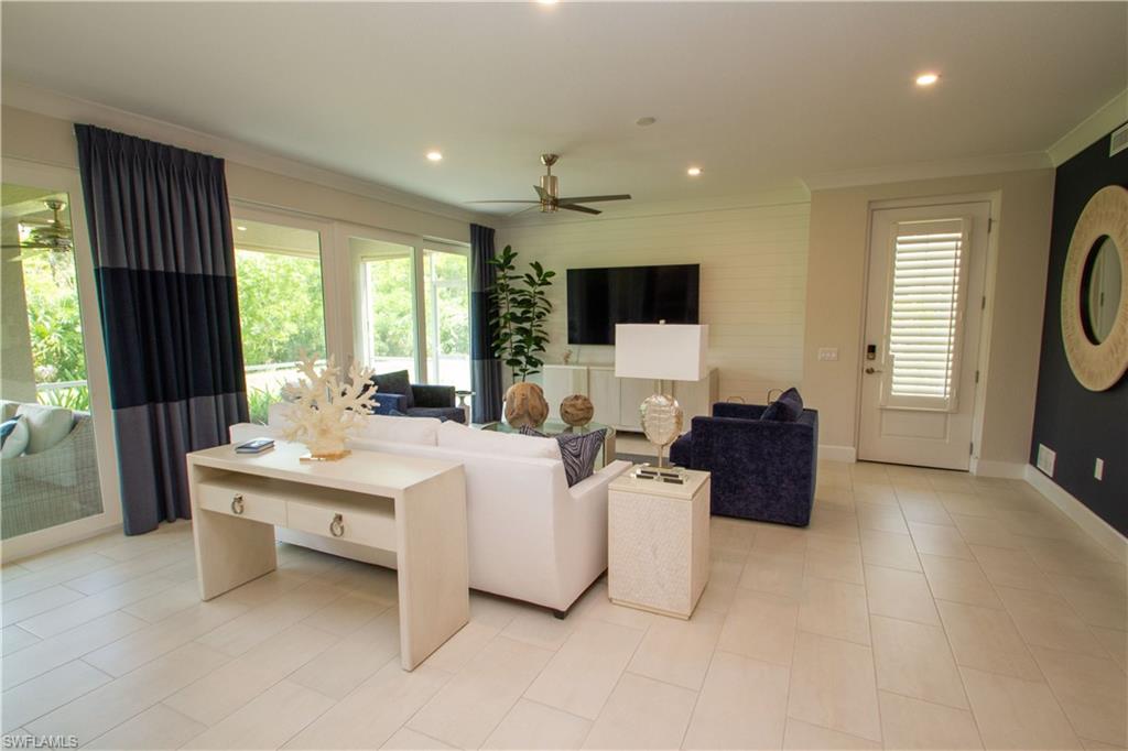 172 Indies Drive East, Unit 8102 Naples, FL 34114 - Photo 22 of 49 a living room with furniture a flat screen tv and a large window