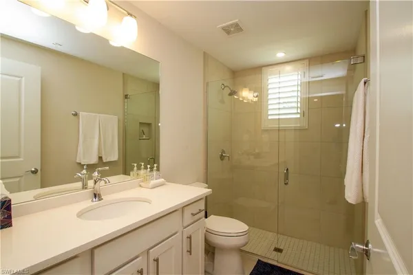 a bathroom with a sink toilet a mirror and shower