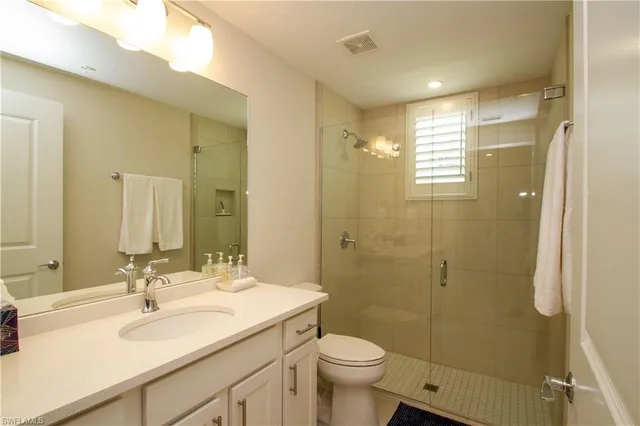 a bathroom with a sink toilet a mirror and shower