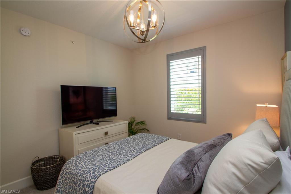 172 Indies Drive East, Unit 8102 Naples, FL 34114 - Photo 25 of 49 a bedroom with a bed and a flat screen tv