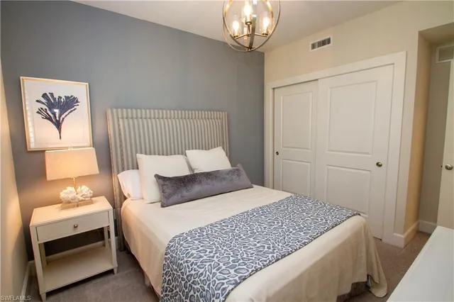 a bedroom with a bed and a chandelier