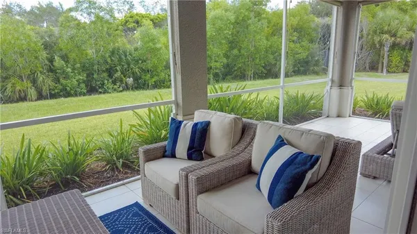 a view of a patio with lawn chairs next to a yard