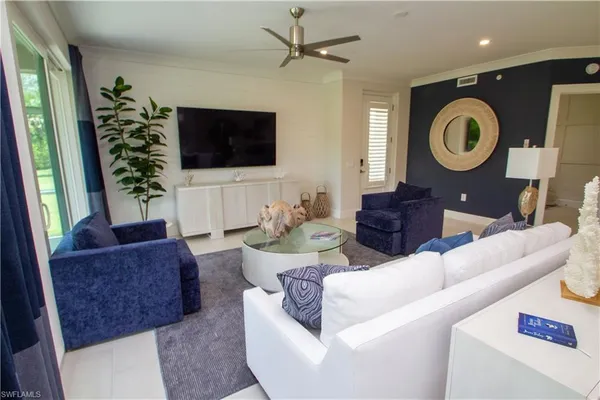a living room with furniture a flat screen tv and a window