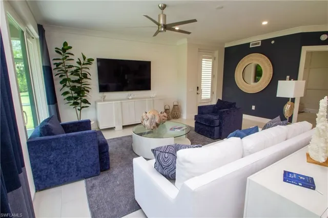a living room with furniture a flat screen tv and a window