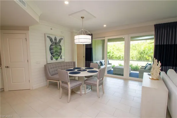 a dining room with furniture a chandelier and wooden floor