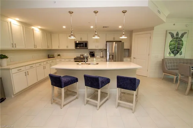 a kitchen with a dining table chairs and white cabinets