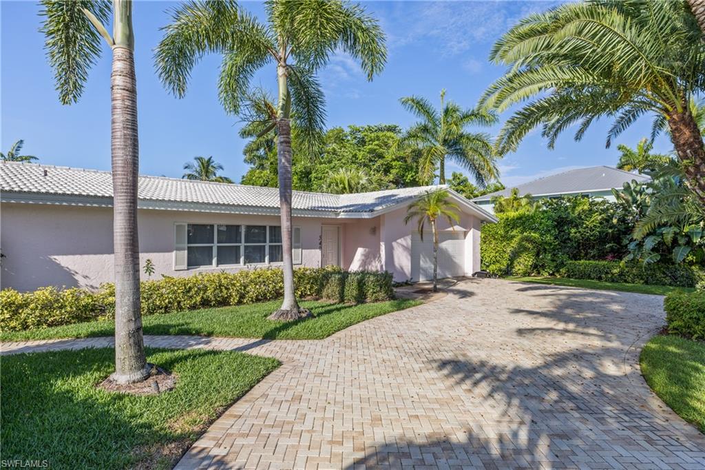 540 Rudder Road Naples, FL 34102 - Photo 14 of 37 Ranch-style house featuring a tile roof, stucco siding, an attached garage, decorative driveway, and a front lawn