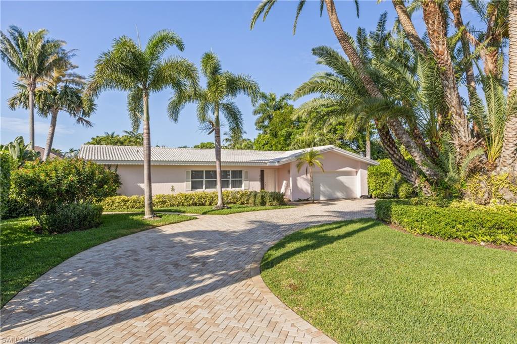 540 Rudder Road Naples, FL 34102 - Photo 2 of 37 Single story home with a front yard, decorative driveway, an attached garage, and stucco siding