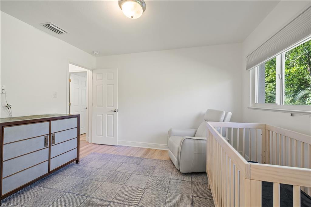 540 Rudder Road Naples, FL 34102 - Photo 23 of 37 Bedroom featuring baseboards, visible vents, and wood finished floors