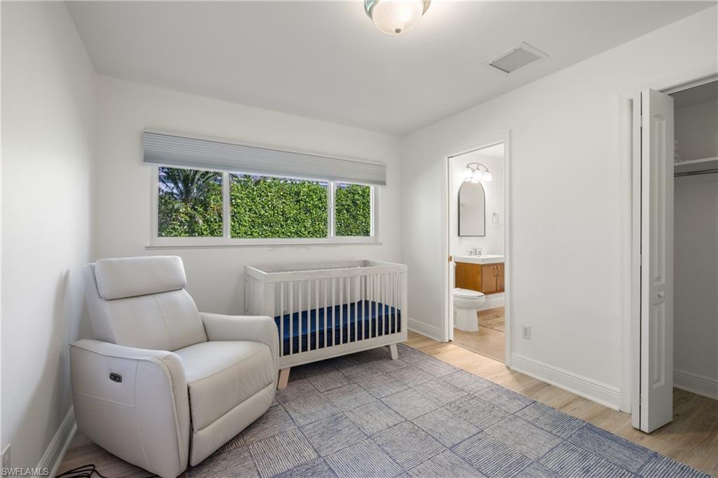 540 Rudder Road Naples, FL 34102 - Photo 24 of 37 Bedroom featuring wood finished floors, ensuite bath, baseboards, and visible vents
